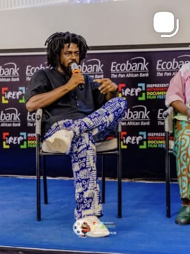 Live coverage of a speaker on the festival stage in front of the Ecobank and iREP backdrop.